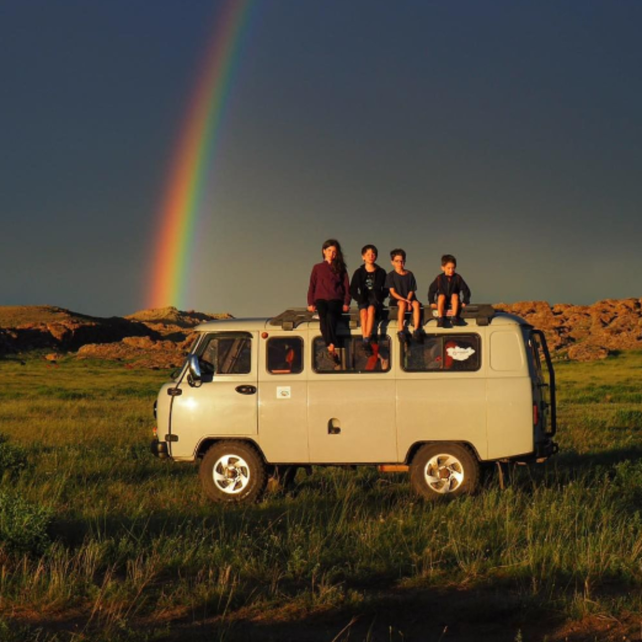 Fotografia da família, com as crianças sentadas em cima de veículo, na Mongolia